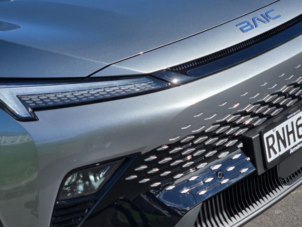 Close up of the LED headlights and BAIC badge of a silver BAIC X55 Premium crossover SUV