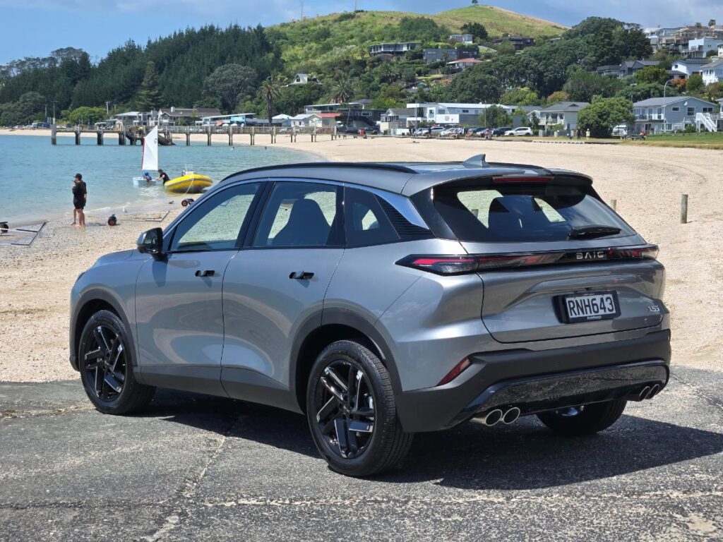 Rear three quarter view of a silver BAIC X55 crossover SUV parked at the beach