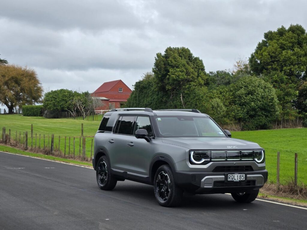 Front three quarter view of a silver BAIC B30 hybrid SUV driving o a country road