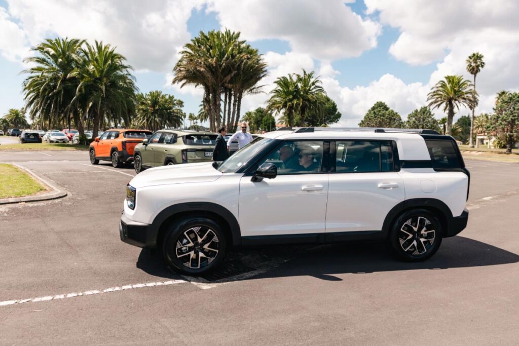 Side view of a white BAIC B30 SUV driving out of a carpark