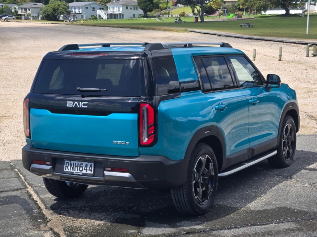 Rear three quarter view of a blue BAIC B30 SUV at a beachside carpartk