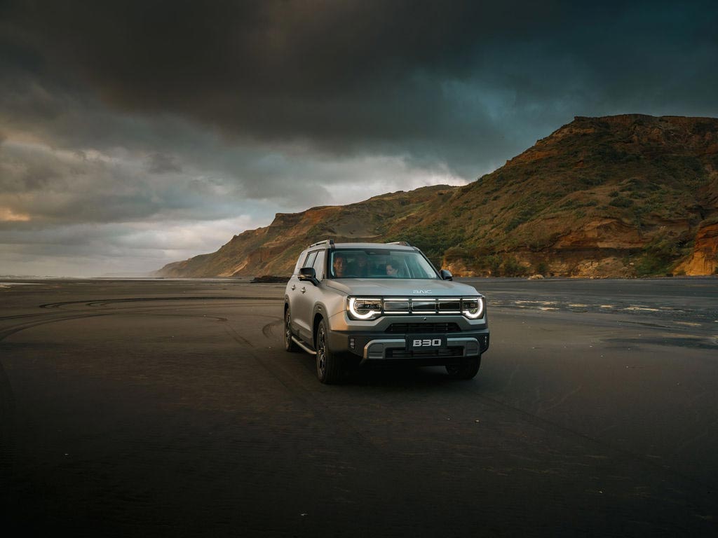 Front view of a grey BAIC B30 driving along a beach